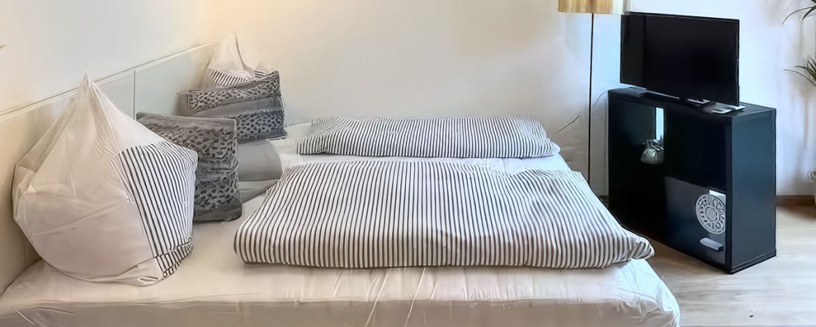 Doppelbett im hellen Wohn-Schlafraum