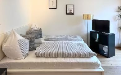 Doppelbett im hellen Wohn-Schlafraum