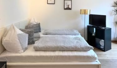 Doppelbett im hellen Wohn-Schlafraum